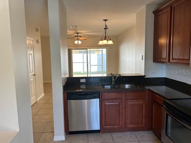 kitchen with pendant lighting, sink, light tile patterned floors, ceiling fan, and appliances with stainless steel finishes