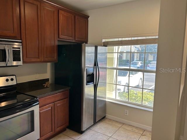 kitchen featuring stainless steel appliances and light tile patterned flooring