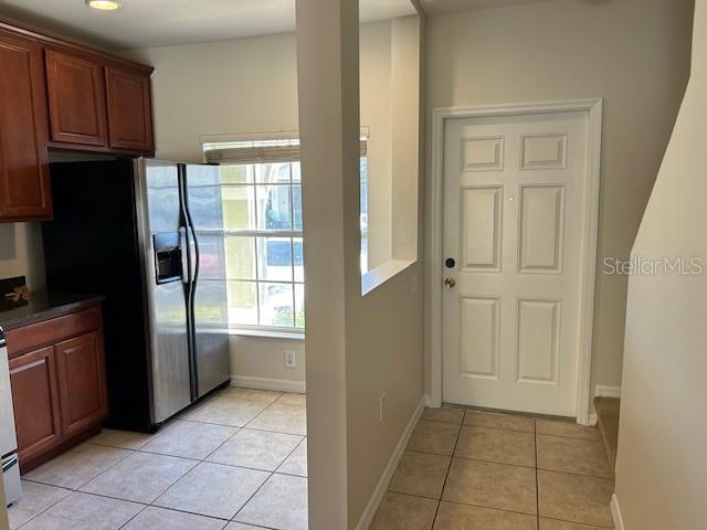 kitchen featuring stainless steel refrigerator with ice dispenser and light tile patterned flooring