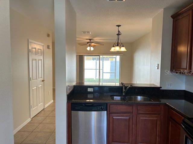 kitchen featuring sink, range, light tile patterned floors, stainless steel dishwasher, and ceiling fan