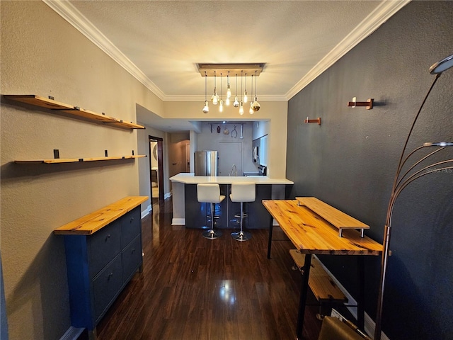 interior space featuring dark hardwood / wood-style flooring, crown molding, blue cabinetry, stainless steel refrigerator, and hanging light fixtures