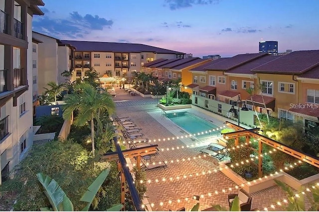 pool at dusk featuring a patio area