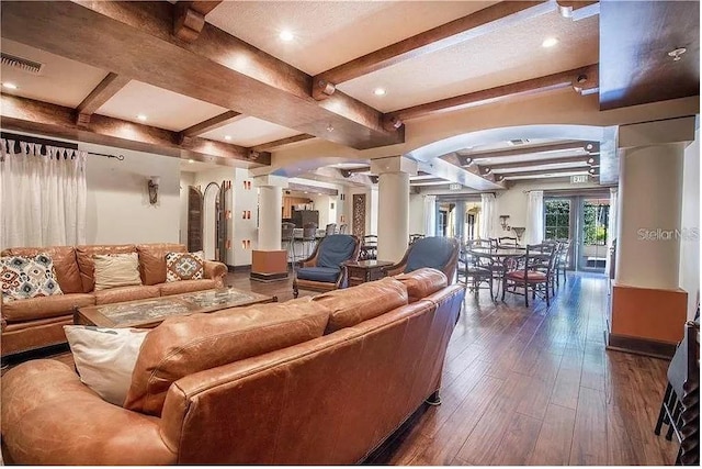 living room with beam ceiling, dark wood-type flooring, and decorative columns