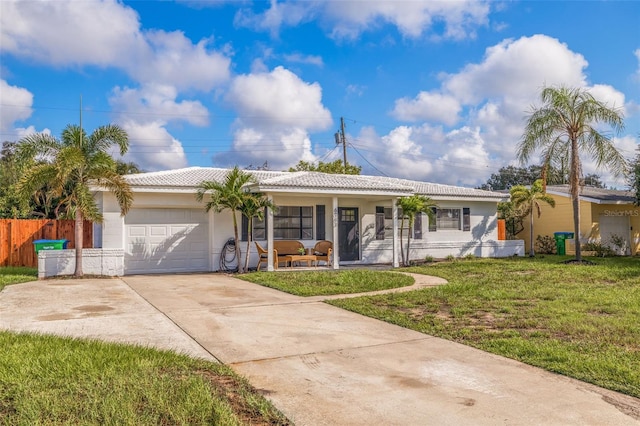 ranch-style house with a front yard, a garage, and covered porch