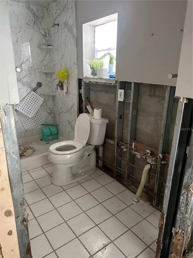 bathroom with toilet, a shower, and tile patterned flooring