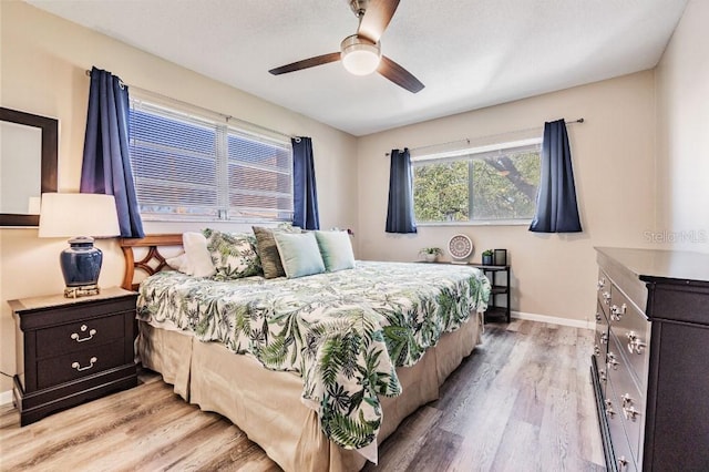 bedroom with light hardwood / wood-style floors and ceiling fan