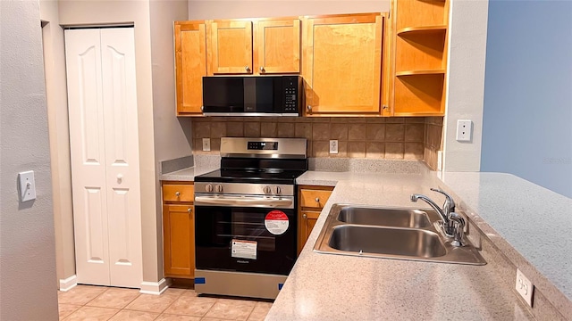 kitchen with sink, light tile patterned flooring, decorative backsplash, and stainless steel stove