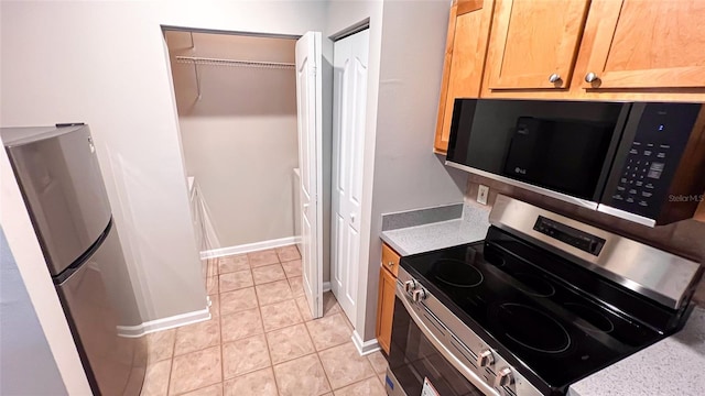 kitchen with appliances with stainless steel finishes and light tile patterned floors