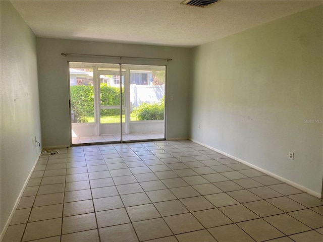 unfurnished room featuring a textured ceiling and light tile patterned floors