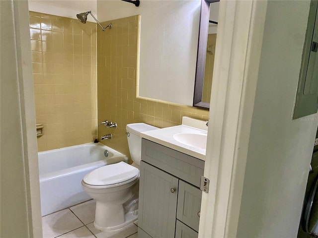 full bathroom featuring tiled shower / bath, vanity, toilet, tile walls, and tile patterned flooring