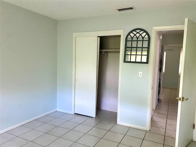 unfurnished bedroom with light tile patterned floors and a closet