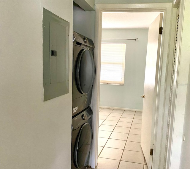 laundry room featuring stacked washer and dryer, electric panel, and light tile patterned floors