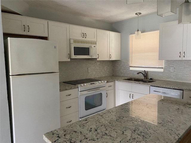 kitchen featuring pendant lighting, white appliances, white cabinetry, and sink