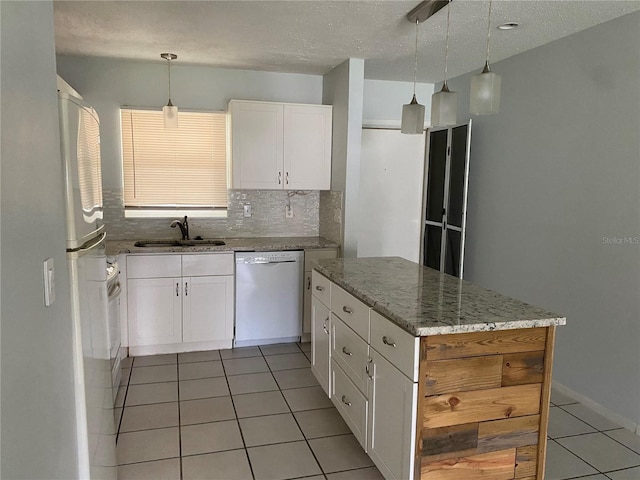 kitchen with white dishwasher, hanging light fixtures, sink, and white cabinetry