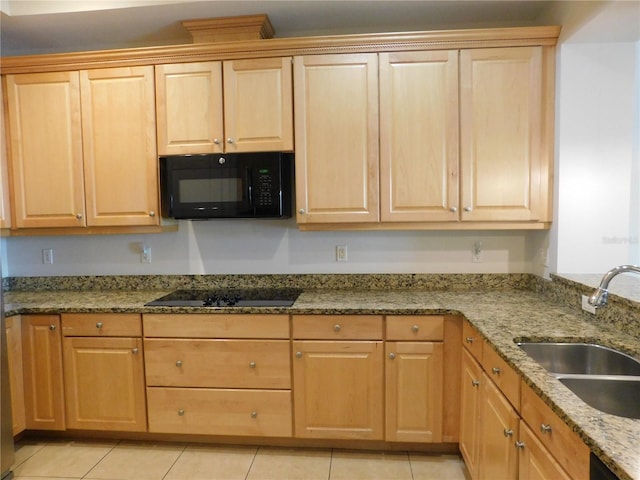 kitchen with black appliances, sink, light stone counters, and light tile patterned floors