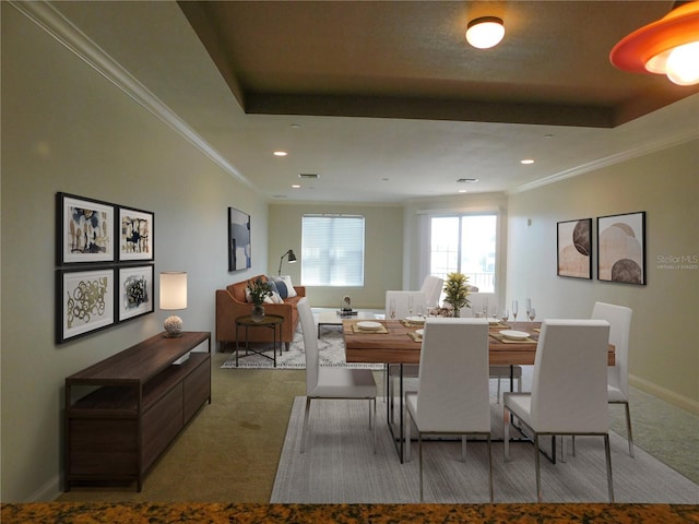 carpeted dining area featuring a raised ceiling and crown molding