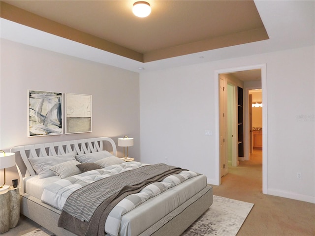 bedroom with a raised ceiling and carpet floors