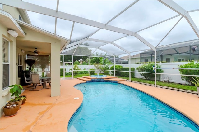 view of swimming pool featuring an in ground hot tub, ceiling fan, glass enclosure, and a patio area