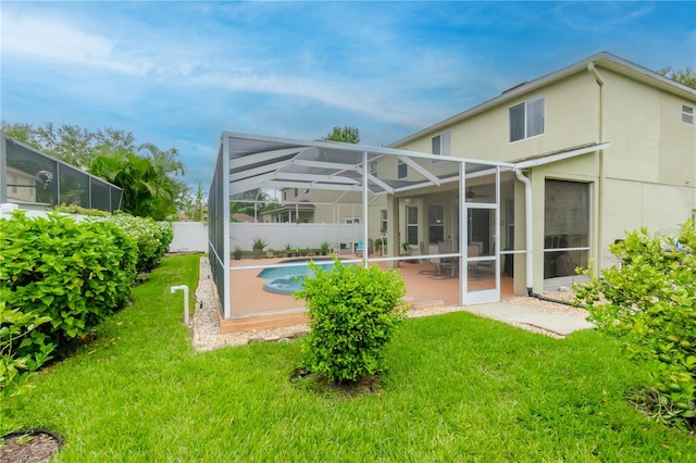 back of house featuring a patio, a yard, a fenced in pool, and glass enclosure