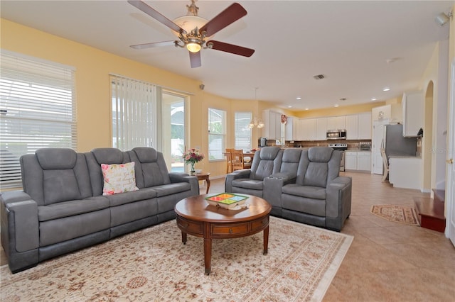 tiled living room with ceiling fan and a wealth of natural light