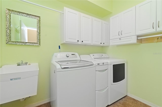 laundry room with sink, light tile patterned floors, cabinets, and independent washer and dryer