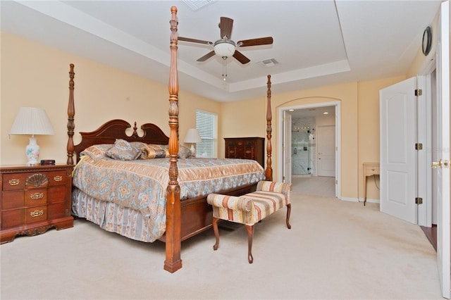 carpeted bedroom featuring a raised ceiling and ceiling fan