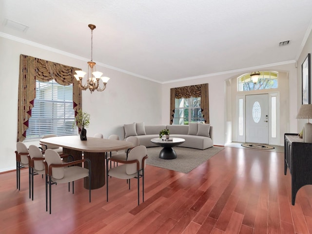 dining room featuring hardwood / wood-style flooring, ornamental molding, and a healthy amount of sunlight