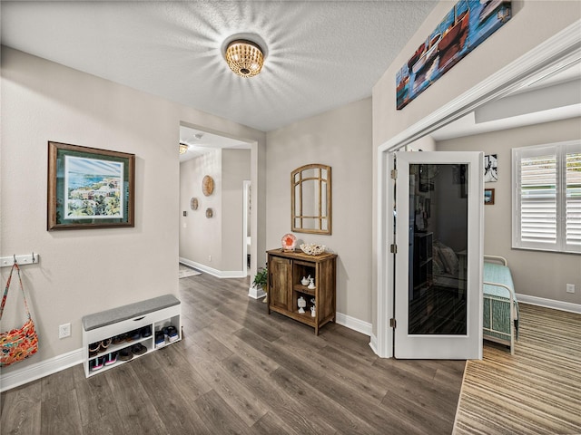 hallway featuring dark hardwood / wood-style floors and a textured ceiling