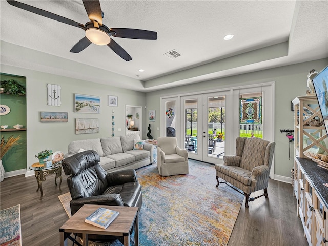 living room featuring french doors, a textured ceiling, dark wood-type flooring, and ceiling fan