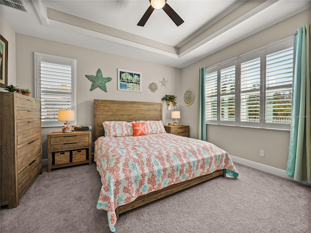 bedroom featuring a tray ceiling, carpet flooring, and ceiling fan