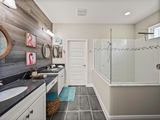 bathroom with vanity, a tile shower, and tile patterned flooring