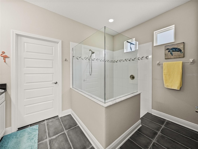 bathroom featuring vanity, tile patterned flooring, and tiled shower