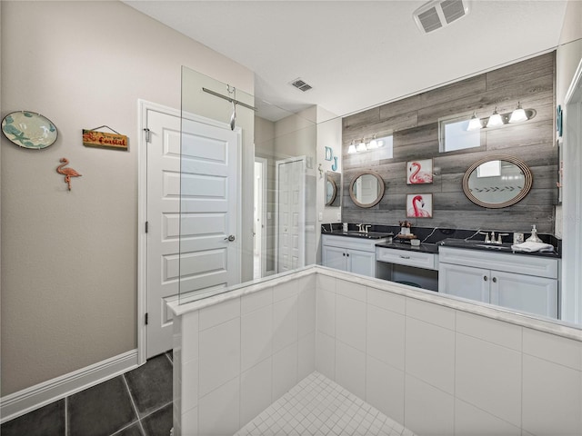 kitchen with tasteful backsplash, sink, dark tile patterned floors, hanging light fixtures, and white cabinetry