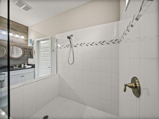 bathroom with vanity and a tile shower