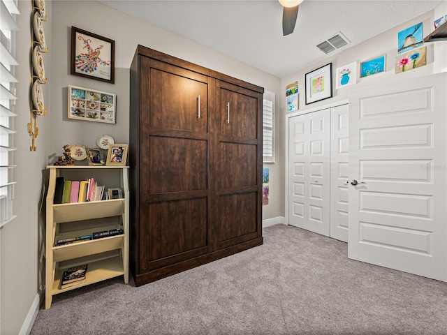 bedroom featuring a closet, ceiling fan, and light carpet