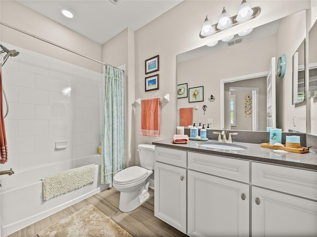 full bathroom with toilet, shower / bath combo with shower curtain, a healthy amount of sunlight, hardwood / wood-style floors, and vanity