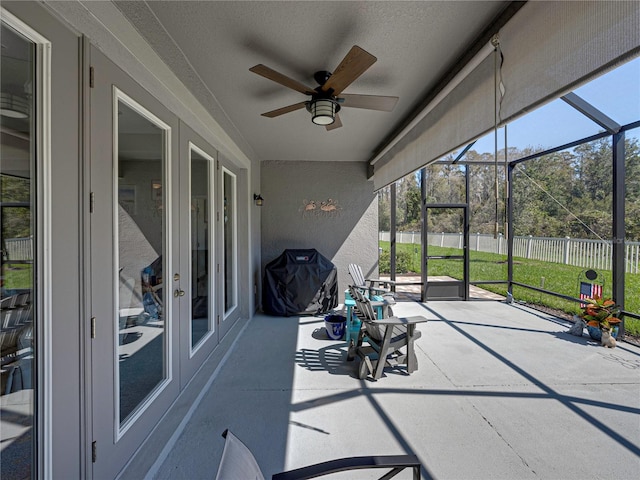 unfurnished sunroom featuring ceiling fan