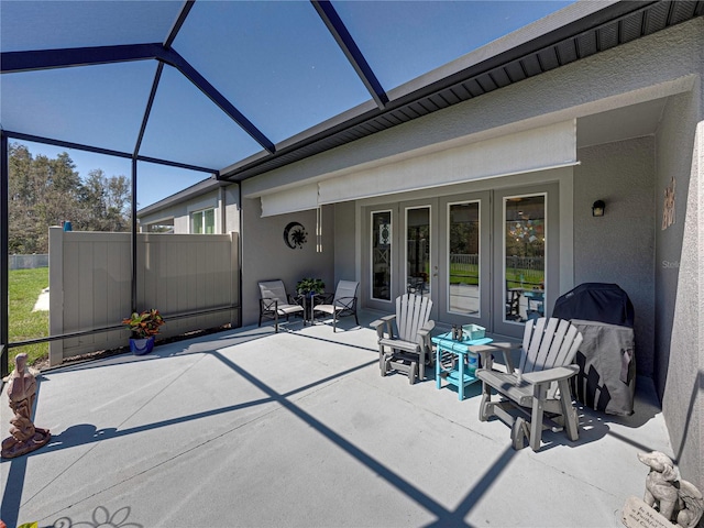 view of patio featuring glass enclosure