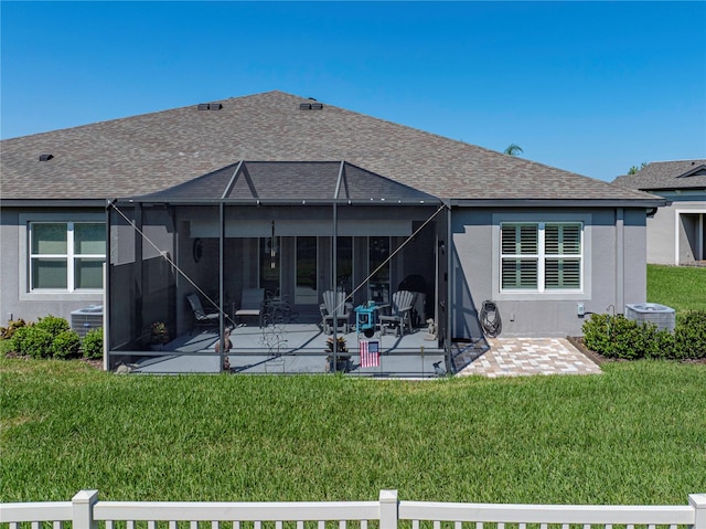 rear view of house with central AC, a patio area, a lawn, and a lanai