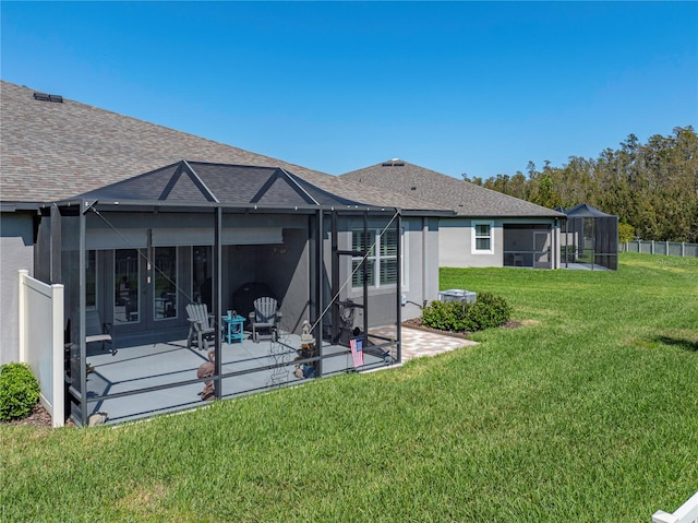 rear view of house with a patio, a lanai, and a yard