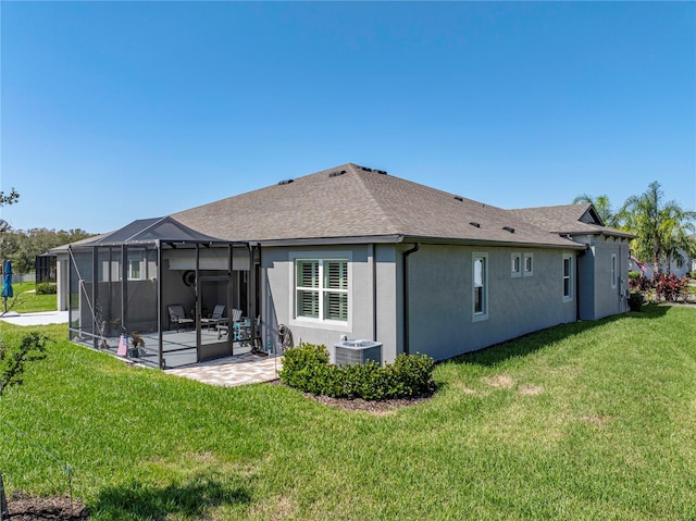 back of house featuring central air condition unit, a patio area, a lawn, and glass enclosure