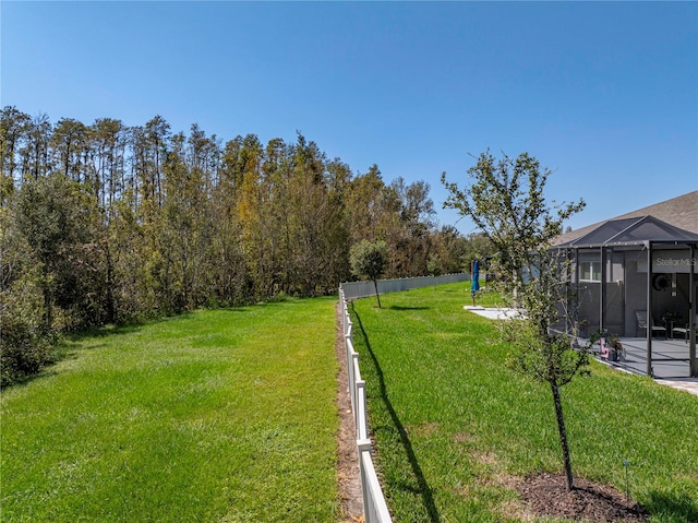 view of yard featuring a patio and glass enclosure