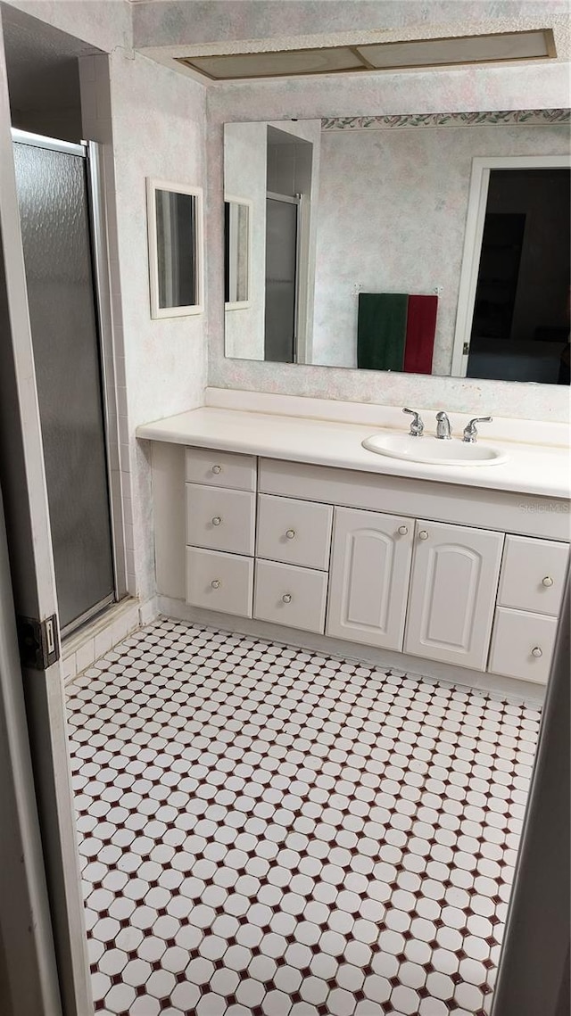 bathroom featuring vanity and a shower with door