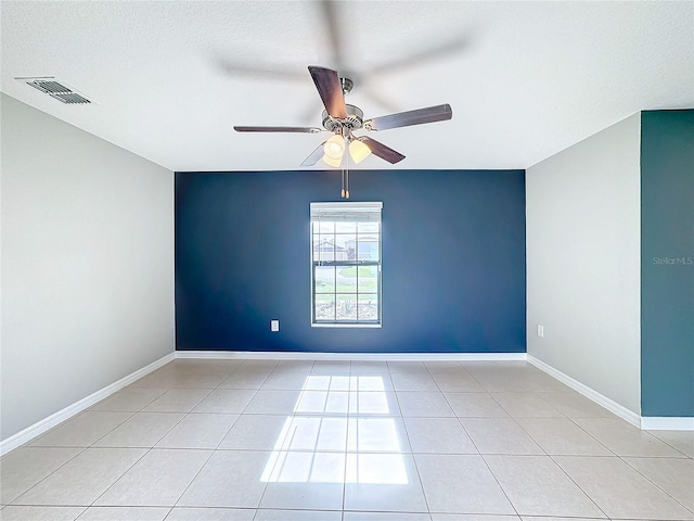 tiled spare room with a textured ceiling and ceiling fan