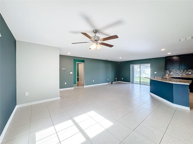 unfurnished living room featuring light tile patterned flooring and ceiling fan