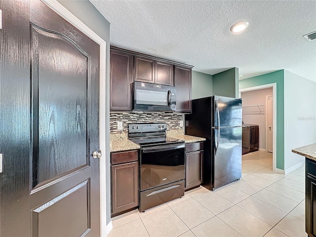 kitchen with black appliances, washer and clothes dryer, backsplash, dark brown cabinets, and light stone countertops