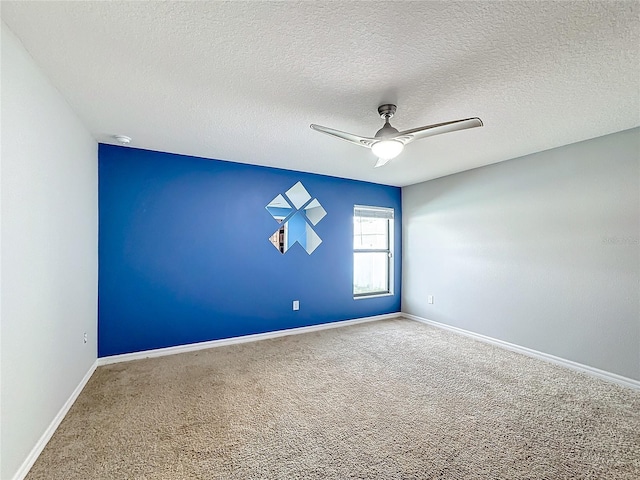 carpeted spare room with ceiling fan and a textured ceiling