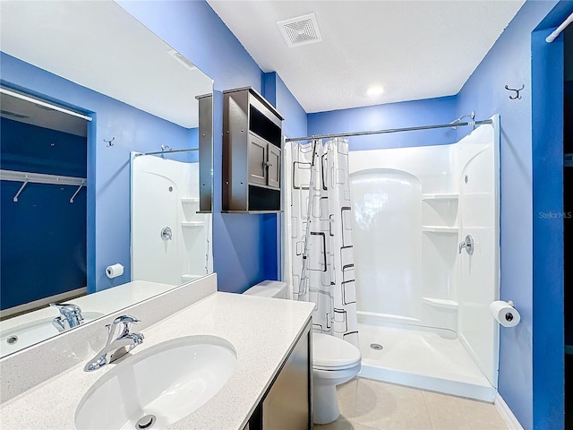 bathroom with toilet, vanity, a shower with shower curtain, and tile patterned floors