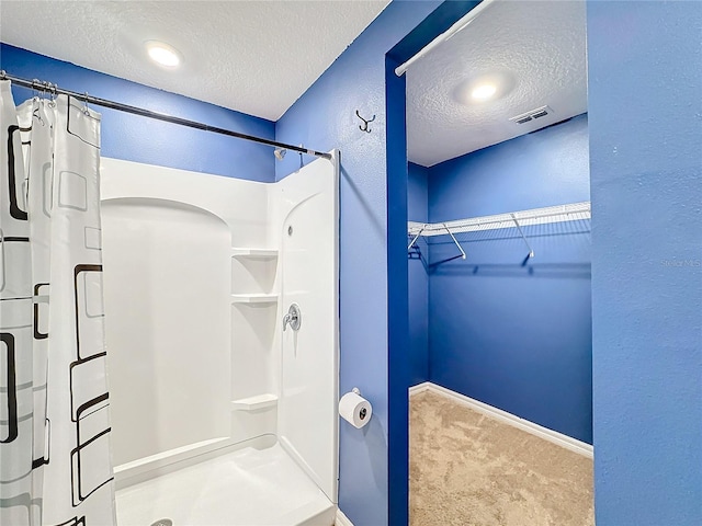 bathroom featuring walk in shower and a textured ceiling