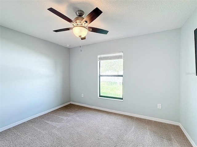 carpeted spare room featuring ceiling fan and a textured ceiling